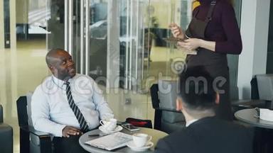 非裔美国商人在午餐时间和他的白人<strong>伴侣</strong>在优雅的<strong>咖啡</strong>馆里微笑着喝<strong>咖啡</strong>