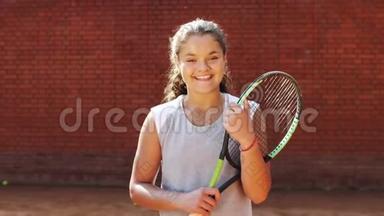 漂亮的年轻网球运动员站在球拍上的肖像。