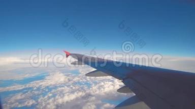 飞机飞行。 飞行在云层之上的飞机的机翼。 从平面的窗口查看.. 飞机。 旅行