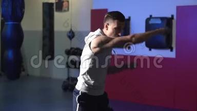 慢动作，微光场景男拳击手在健身房训练，皮影戏。