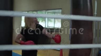 女人在健身房用拳袋打拳