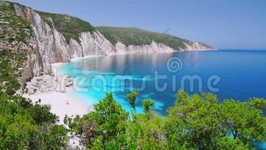 希腊，基法隆尼亚，有岩石海岸线的蓝色泻湖。平静清澈的蓝绿色绿松石海水。白沙滩
