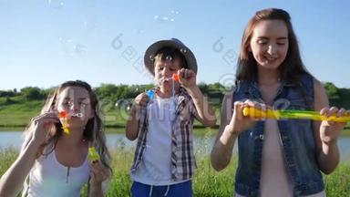 欢乐的童年，欢乐的孩子们在背景天空的洛夫附近的草坪上用肥皂泡