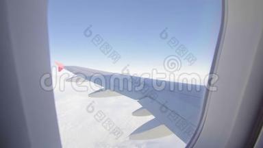 飞机飞行。 飞行在云层之上的飞机的机翼。 从平面的窗口查看.. 飞机。 旅行