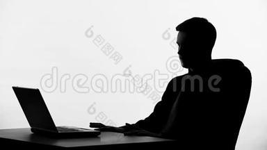 商务人士坐在笔记本电脑前的剪影，思考商业<strong>提案</strong>