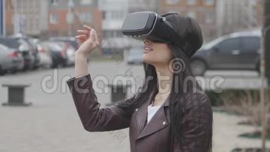 年轻的黑发女人在城市的街道上体验使用虚拟现实耳机或虚拟现实耳机