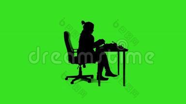 办公桌办公室的绿色屏幕<strong>剪影女士</strong>，配有打字机