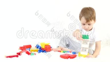 快乐的孩子坐在白色的背景上，在彩色的积木里玩耍。一个孩子在沙发上玩。运动摄像机