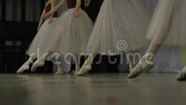 芭蕾。 在芭蕾训练中，一个穿白色芭蕾舞鞋的女孩`了她的腿。 古典舞的元素。 4K