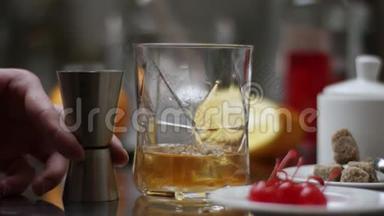 酒吧老板把威士忌倒在杯子里，木桌上放<strong>冰块</strong>，黑黑的背景重点放在<strong>冰块</strong>上，威士忌上