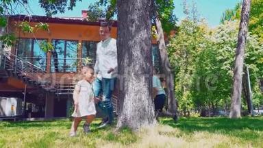 年轻的父亲带着孩子在房子附近的一棵树上跑来跑<strong>去</strong>，<strong>爸爸</strong>、儿子和小女儿在后院玩得很开心