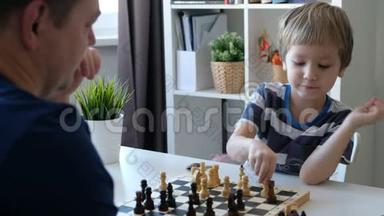小男孩和他父亲下棋。 教育和家庭观念