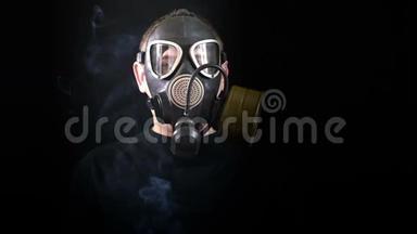 一个戴防毒面具的人在黑色背景下的脸，可以防止烟雾。 特写