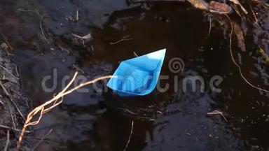 <strong>小小</strong>的蓝色纸船上流淌着一条透明的河流，倒映在其中的树木。 近点