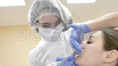 牙医在口罩检查牙齿给病人。 医生治疗牙齿。