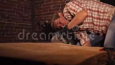 成年男子在工作间使用电动工具打磨木板