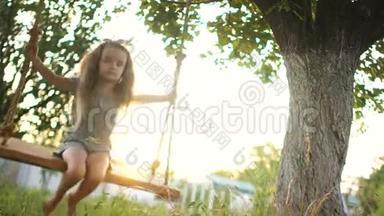 这位学龄前女孩用严肃而专注的脸在秋千上摇摆。 动态视频。 暑假快乐