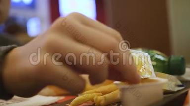 一个男孩在快餐店吃薯条。 快餐。 健康食品