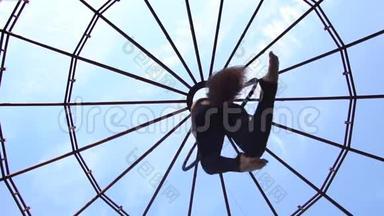 一个深色头发的女人在空中杂技表演时的底部景色