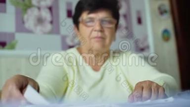 老年妇女在眼镜中的注意力不集中，检查家里的日常<strong>开支</strong>