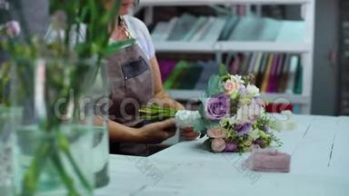 在花艺设计工作室，专业的花艺师用丝带布置婚礼花束