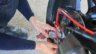 男子摩托车轮胎手动气压测试，在出行前安全乘车