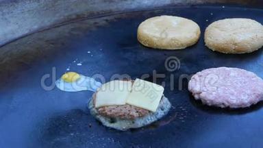 厨师用吹火把把奶酪融化在肉切片上。 厨师用吹火把把奶酪融化在汉堡上。