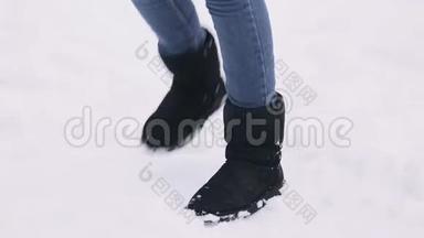 一个年轻女孩跳起来保暖的腿。 那个女人在一个白雪覆盖的冬季公园里冻僵了。