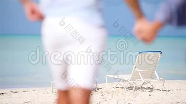 快乐的一对夫妇在热带海滩上放松。 两个家庭一起在加勒比海散步