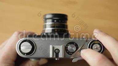摄影师将旧胶片相机的胶片倒带，按下按钮..