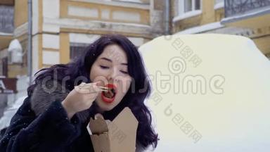 年轻的<strong>韩国人</strong>在下雪时在街上吃面条