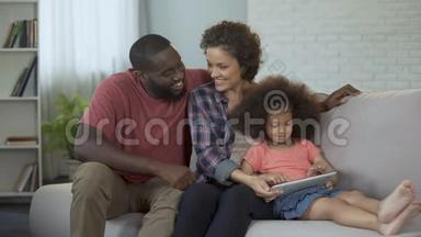 父母看着他们的小女儿在平板电脑上<strong>应对</strong>教育应用程序