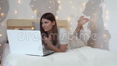 一个漂亮的女孩躺在床上，喜欢笔记本<strong>电脑</strong>。 高清高清