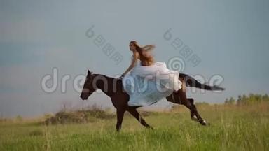 两个穿着白色连衣裙的<strong>女孩</strong>骑马。 <strong>女孩</strong>们骑马在<strong>田野</strong>上跳跃。 慢动作。
