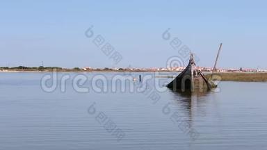 独孤沉舟半沉于葡萄牙阿维罗泻湖河口.. 地平线上的小镇。