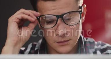 头痛的疲倦的人把坐在笔记本电脑前的眼镜摘下。 商务、人事、通信、技术