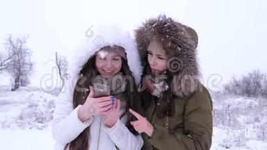 冬天，迷人的女孩在下雪时坐在社交网络中使用小工具