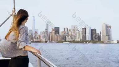 快乐成功的女商人，头发随风飘动，在游艇上欣赏纽约曼哈顿壮观的天际景色