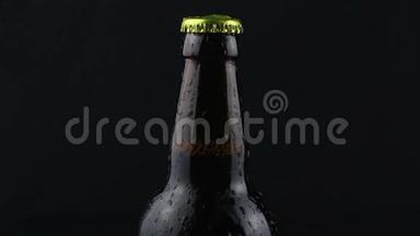 <strong>凝结</strong>水滴在黑暗的背景下从啤酒瓶中流出。 一瓶雾蒙蒙的啤酒。