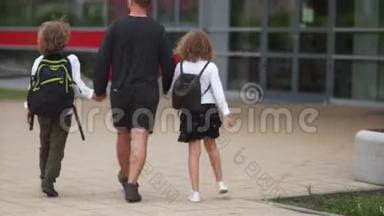 父亲带领孩子<strong>上学</strong>.. 一个男人抱着一个男孩和一个<strong>女孩</strong>。 他们带着背包<strong>上学</strong>。 回到过去
