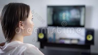 独自一人的女孩晚上坐在她家的客厅里看电视，集中精力看电影<strong>情节</strong>