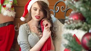 圣诞<strong>老人</strong>戴着圣诞<strong>老人</strong>帽子的年轻女子在装饰圣诞树附近的<strong>肖像</strong>。 很漂亮的女人微笑。 新年