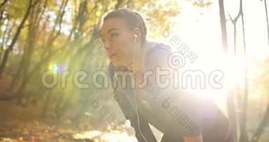 公园里的女跑步者。阳光明媚，劳累的穿健身服的年轻女子<strong>长时间</strong>休息后的特写镜头
