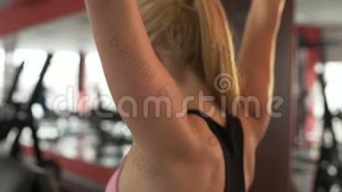 年轻女子在健身房做后拉运动，锻炼出<strong>有梦想</strong>的身体