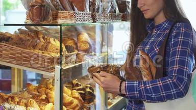 一名女顾客在面包店里检查一包饼干时被打了弯
