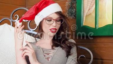 <strong>圣诞老人</strong>戴着<strong>圣诞老人帽子</strong>的年轻女子在装饰圣诞树附近的肖像。 很漂亮的女人微笑。 新年