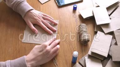 女人用牛皮纸做了一个纸袋，用来做日历。 双手特写.. 弯曲尺子。