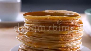 美味<strong>可口</strong>的新鲜薄煎饼等着在桌上吃，在木制的表面上撒上融化的金色蜂蜜