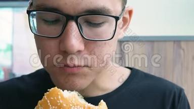 一个脸上长痘痘的年轻人吃汉堡包。
