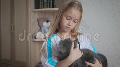 小女孩在家和猫玩医生。 女孩扮演兽医与家庭宠物。